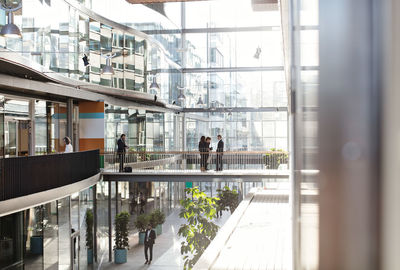 Male and female business people standing at modern office atrium