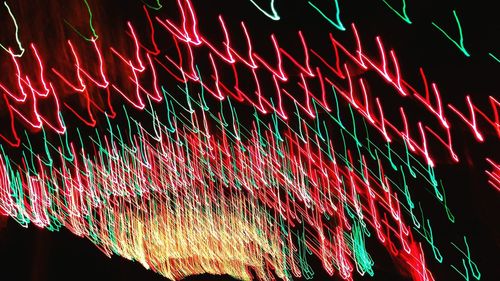 Low angle view of illuminated fireworks against sky at night