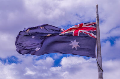 Low angle view of flag flags against sky