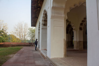 Rear view of man walking amidst buildings