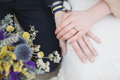 Midsection of couple showing rings during wedding ceremony