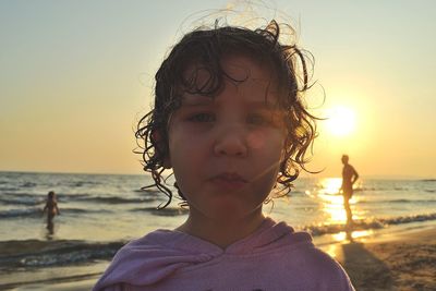 Portrait of boy on beach against sky during sunset