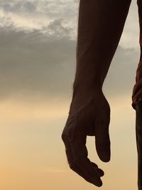 Low section of silhouette person against sky during sunset