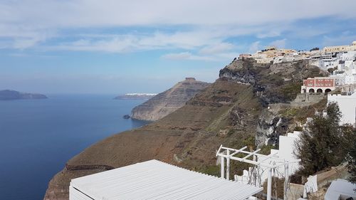 Buildings by sea against sky