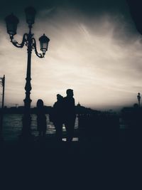 Silhouette people standing against sky during sunset