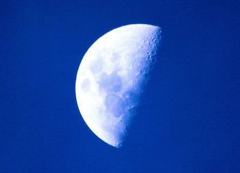 Low angle view of moon in blue sky