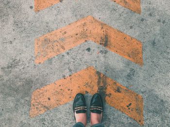 Low section of woman standing on road