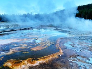 Panoramic view of geyser against sky