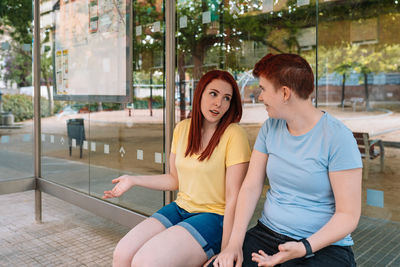 Woman talking with friend bus station