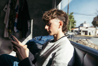 Portrait of trendy teenager boy using mobile phone