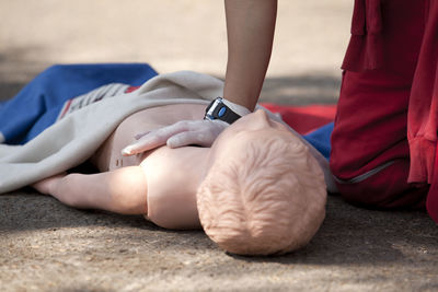 Midsection of paramedic performing cpr on dummy