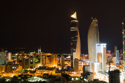 Illuminated buildings in city against sky at night