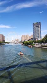 Bridge over river against buildings in city