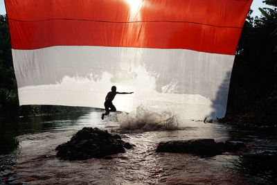 Silhouette man surfing in sea