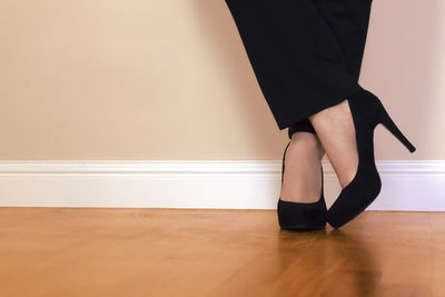 Low section of woman standing on hardwood floor