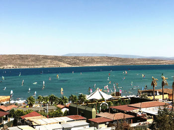 High angle view of buildings by sea against clear sky