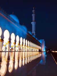 Illuminated mosque in city at night