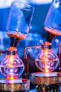 Close-up of illuminated glass bottle on table