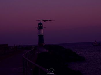 View of lighthouse by sea against sky