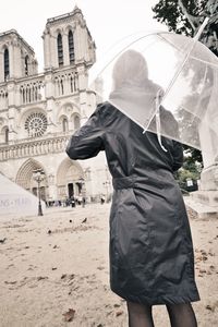 Woman with umbrella looking at cathedral notre dame