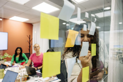 Young businesswoman conducting brainstorming session with colleagues during meeting at office