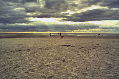 People walking on beach against sky