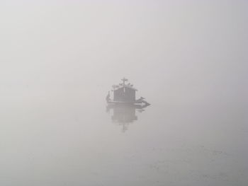 Ship in sea against sky during foggy weather