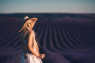 Woman wearing hat standing on flower field