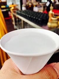 Close-up of hand holding coffee cup on table