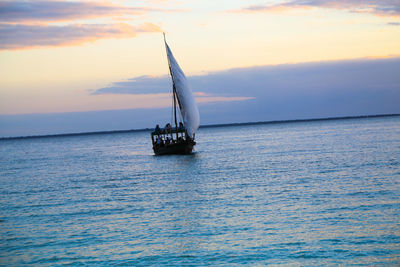 Boat sailing on sea against sky during sunset