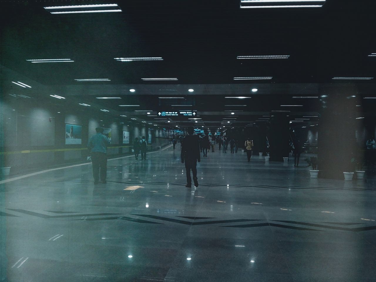 PEOPLE WALKING ON ILLUMINATED WALKWAY IN CITY