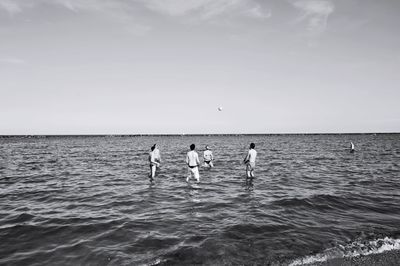 People standing on beach against sky