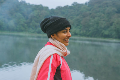 Portrait of a smiling young woman in lake during winter