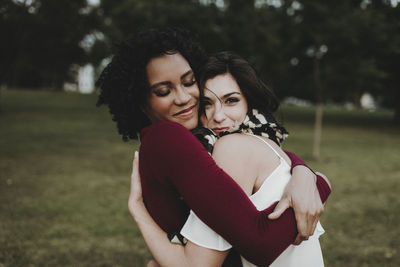 Female friends embracing at park