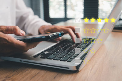 Midsection of man using laptop on table