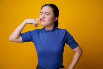 Mid adult man standing against yellow wall