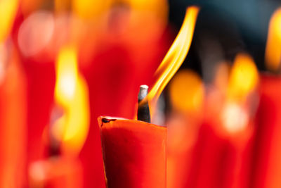 Rows of burning red candles are used in religious prayers