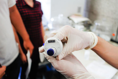 Cropped image of hand holding burette in laboratory