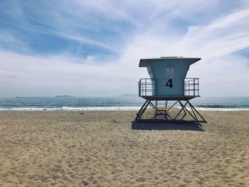 Lifeguard hut on beach against sky