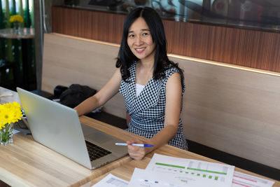 Portrait of smiling young woman using mobile phone