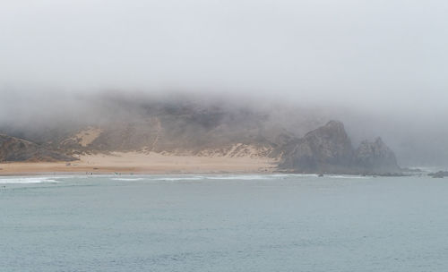 Scenic view of sea and mountains against sky