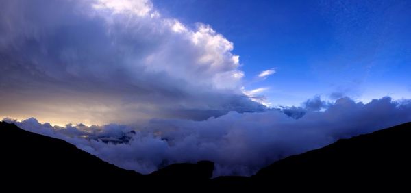 Scenic view of mountains against cloudy sky