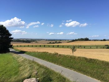 Scenic view of fields against blue sky