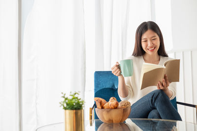 Young woman sitting on book