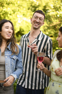 Portrait of smiling friends standing in park