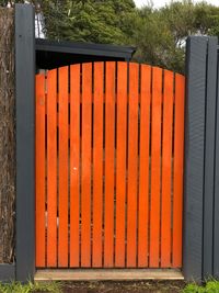View of metal fence against orange wall