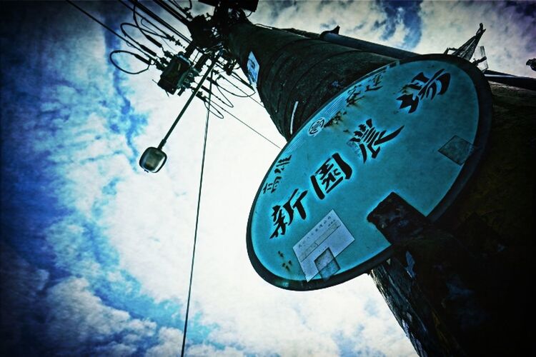 low angle view, communication, sky, text, western script, blue, cloud - sky, road sign, electricity, guidance, day, technology, no people, number, information sign, outdoors, cloud, sign, arrow symbol, built structure