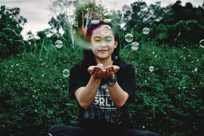 Low angle view of young woman holding flower