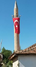 Low angle view of lighthouse against clear blue sky