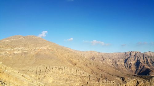 Scenic view of desert against blue sky